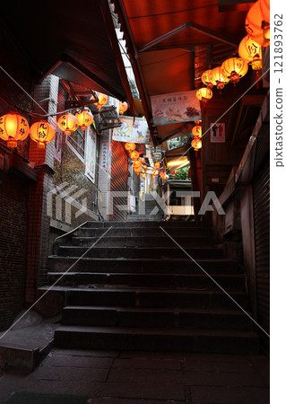 The back alleys of Jiufen exude a nostalgic, retro charm. Red lanterns gently illuminate the narrow staircase at dusk. The back alleys of Jiufen exude a nostalgic, retro charm. Red lanterns gently illuminate the narrow staircase at dusk. 121893762