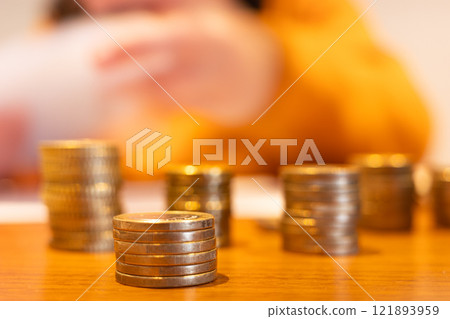 Closeup of stacks of coins on wooden table with blurred background representing finance and saving money Closeup of stacks of coins on wooden table with blurred background representing finance and saving money 121893959