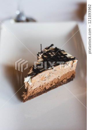 High angle of piece of delicious chocolate cake placed on white table 121893962