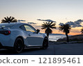 A white sports car parked by the sea at sunset 121895461