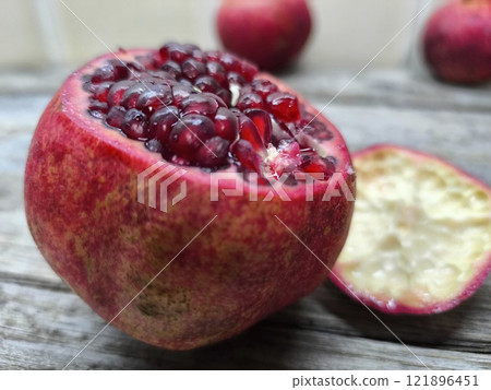Sweet red pomegranate on a wooden table. Sweet red pomegranate on a wooden table. 121896451