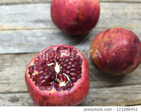 Sweet red pomegranate on a wooden table. 121896452
