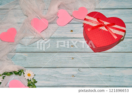 Red heart box, pink hearts on blue planks with white cloth and flowers Red heart box, pink hearts on blue planks with white cloth and flowers 121896653
