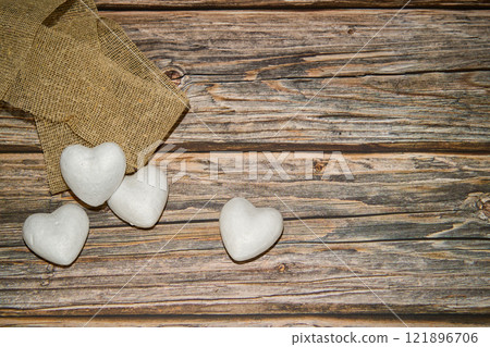 Marble stones in the shape of heart and cloth on wooden table Marble stones in the shape of heart and cloth on wooden table 121896706