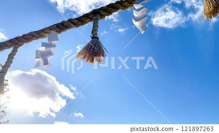 Shinto ropes and paper streamers shining in the blue sky Shinto ropes and paper streamers shining in the blue sky 121897263
