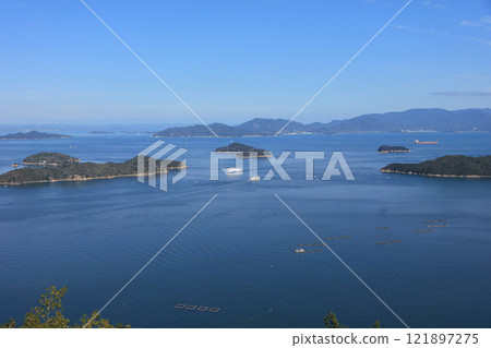 大型渡輪和國際渡輪 11 號國際丸在瀨戶內海高松海岸的備山瀨戶交匯。 121897275