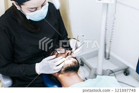 Dentist checking braces to patient, patient checked by dentist, Dentist performing dental checkup 121897748