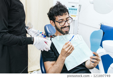 Patient with dentist choosing dental braces, Dentist with patient choosing metal braces, Patient with dentist choosing rubber band Patient with dentist choosing dental braces, Dentist with patient choosing metal braces, Patient with dentist choosing rubber band 121897749