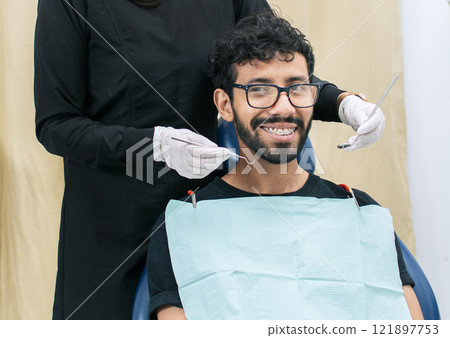 Dentist examining mouth to smiling patient, Female dentist doing root canal to female patient, Female dentist with lying patient, Dentist performing stomatology 121897753