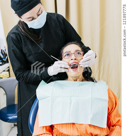 Dentist performing dental checkup, Patient checked by dentist, close up of dentist with patient, dentist performing root canal treatment on patient 121897778