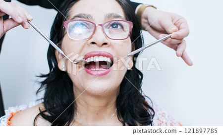 Close up of dentist with patient, dentist performing root canal treatment on patient, dentist performing dental checkup, Patient checked by dentist Close up of dentist with patient, dentist performing root canal treatment on patient, dentist performing dental checkup, Patient checked by dentist 121897785