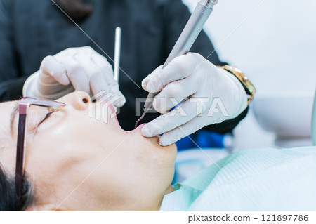 Close up o patient checked by dentist, dentist performing root canal treatment on patient, dentist performing dental checkup 121897786