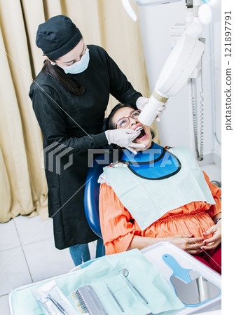 Female dentist doing dental x-ray, Female dentist doing x-ray to patient, female dentist doing dental x-ray, dental x-ray concept Female dentist doing dental x-ray, Female dentist doing x-ray to patient, female dentist doing dental x-ray, dental x-ray concept 121897791