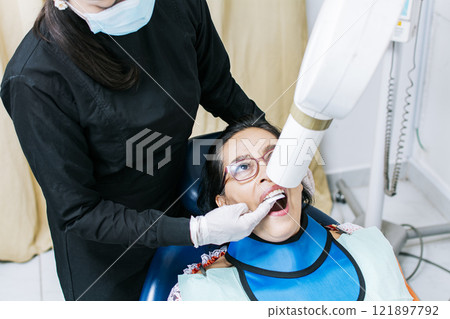 Female dentist doing dental x-ray, Female dentist doing x-ray to patient, female dentist doing dental x-ray, dental x-ray concept Female dentist doing dental x-ray, Female dentist doing x-ray to patient, female dentist doing dental x-ray, dental x-ray concept 121897792
