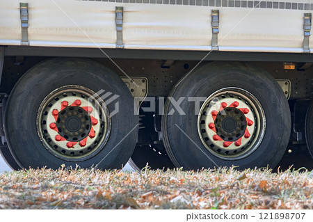 Two large wheels of a heavy duty long haul trailer 121898707
