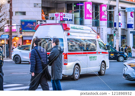 Tokyo cityscape, Japan: An ambulance with its siren on passes the intersection of Sotokanda 5-chome in front of Suehirocho Station 121898932