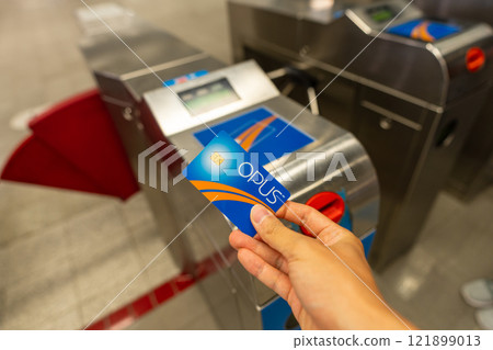 Montreal, Quebec, Canada - August 20 2021 : Using the OPUS smart card to enter Montreal Metro Berri-UQAM Station ticket gates. 121899013