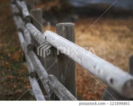A nostalgic photo of a wooden railing in a barren winter landscape 121899861