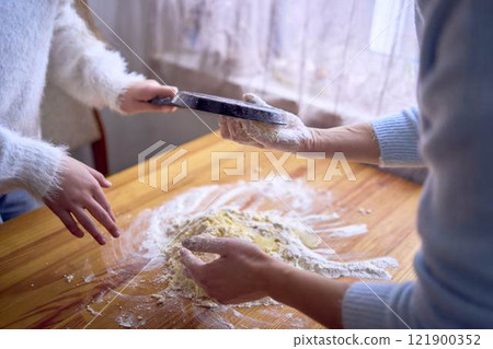 a mother and teenage daughter are cooking cookies together in the kitchen a mother and teenage daughter are cooking cookies together in the kitchen 121900352