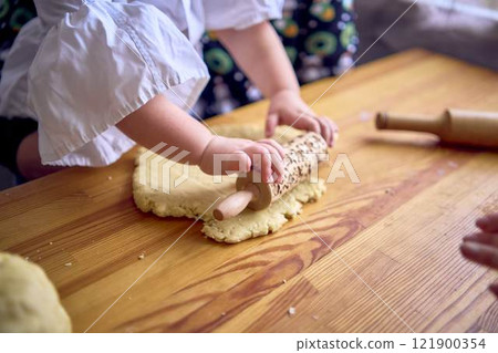 family with two daughters, a teenager and a toddler, cook cookies together in the kitchen family with two daughters, a teenager and a toddler, cook cookies together in the kitchen 121900354
