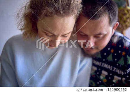 a husband and wife are cooking Christmas cookies in the kitchen 121900362
