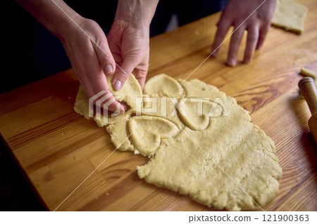 a husband and wife are cooking Christmas cookies in the kitchen 121900363