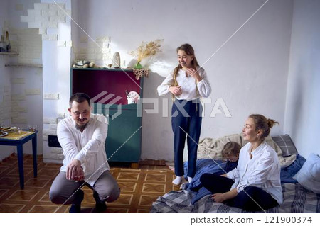 family with toddler and teenager playing games, laughing, clapping and celebrating a small family party family with toddler and teenager playing games, laughing, clapping and celebrating a small family party 121900374