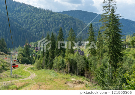 Ski lift in green forest. Cableway in Mountains. Summer nature. Ski lift in green forest. Cableway in Mountains. Summer nature. 121900506