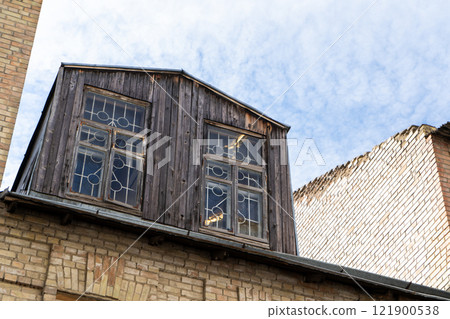 Old wooden attic above the roof of the house. Attic with windows Old wooden attic above the roof of the house. Attic with windows 121900538