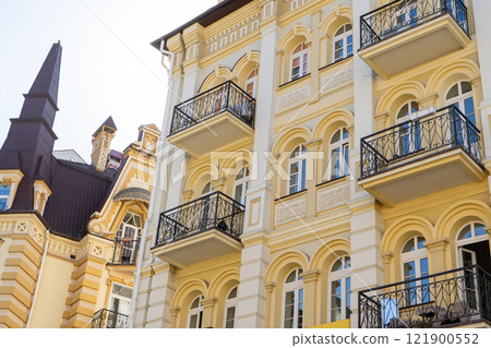 Yellow color modern exterior of houses buildings. Windows balcony facade 121900552