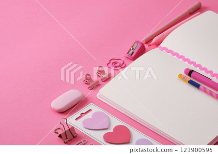 Stationery background in pink color, open notepad and office supplies. A place for your text. 121900595