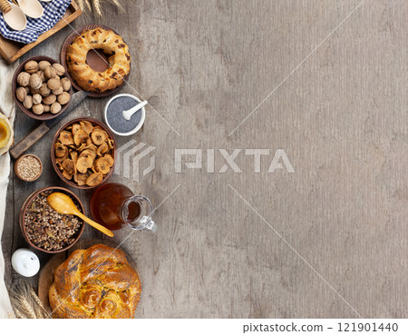 Christmas background. Food on a wooden background top view. Place for the test. Christian Lenten traditional food for Christmas - Kutya, dried fruits, uzvar, poppy seed pie, nuts. Ingredients. Christmas background. Food on a wooden background top view. Place for the test. Christian Lenten traditional food for Christmas - Kutya, dried fruits, uzvar, poppy seed pie, nuts. Ingredients. 121901440