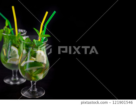 Mojito on a black background. Summer soft drinks with copy space. Lemon, lime, mint, ice, water. Bar menu Mojito on a black background. Summer soft drinks with copy space. Lemon, lime, mint, ice, water. Bar menu 121901546