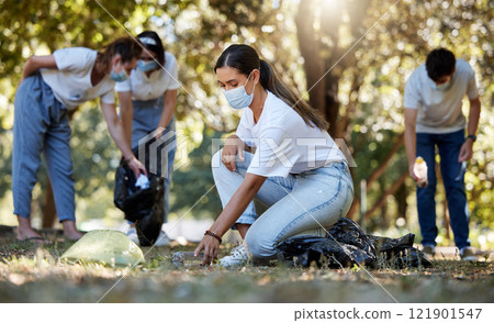 Group of volunteers picking up, cleaning and reducing pollution in a public nature park together. Diverse community wearing face masks to protect from disease, collecting dirt and doing cleanup Group of volunteers picking up, cleaning and reducing pollution in a public nature park together. Diverse community wearing face masks to protect from disease, collecting dirt and doing cleanup 121901547