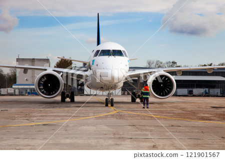 Passenger plane at the airport background. The plane lands at the international airport. White airplane. Terminal Runway. Passenger plane at the airport background. The plane lands at the international airport. White airplane. Terminal Runway. 121901567