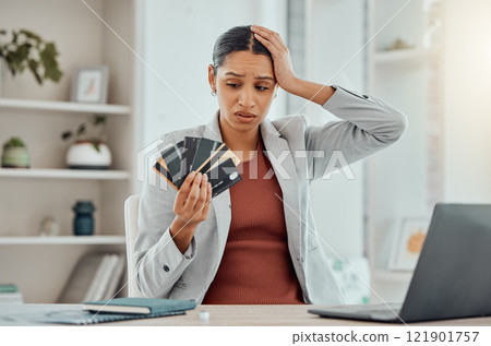 Financial stress, concerned and frustrated woman holding bank cards in her hand at her desk. Business female worried about economic decisions, credit interest or loan and debt in money crisis. 121901757