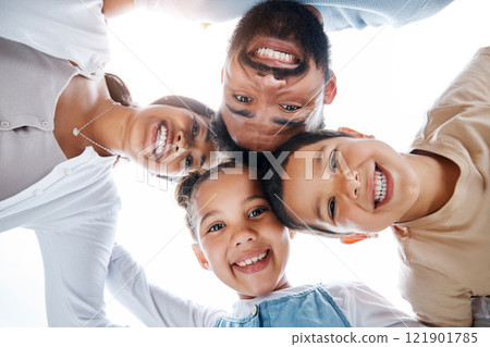 Huddled family bonding, laughing and having fun while standing in a circle with heads in the middle. Below playful portrait of excited, happy and cheerful mother, father and children close together Huddled family bonding, laughing and having fun while standing in a circle with heads in the middle. Below playful portrait of excited, happy and cheerful mother, father and children close together 121901785