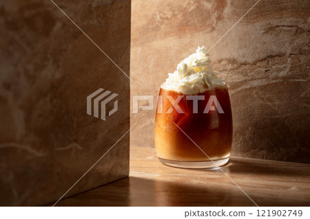 Iced caramel latte topped with whipped cream and caramel sauce. 121902749