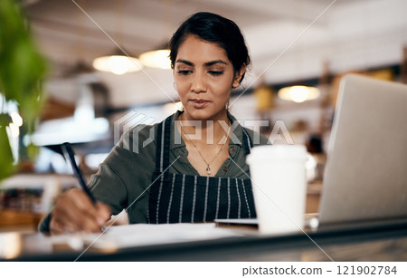 Small business owner working on a budget in her coffee shop and writing a list of stock to order. Serious female entrepreneur developing a growth strategy for her cafe startup Small business owner working on a budget in her coffee shop and writing a list of stock to order. Serious female entrepreneur developing a growth strategy for her cafe startup 121902784