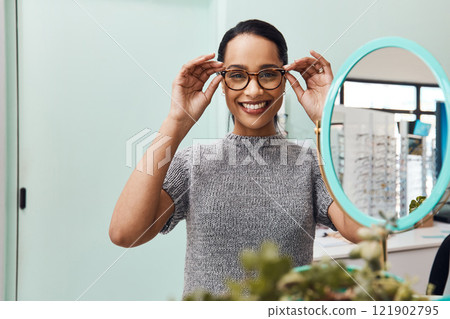Woman wearing pair of trendy glasses, stylish spectacles and new prescription lenses at an optometrist. Portrait of a customer choosing, buying and shopping for frames for better vision and eyesight Woman wearing pair of trendy glasses, stylish spectacles and new prescription lenses at an optometrist. Portrait of a customer choosing, buying and shopping for frames for better vision and eyesight 121902795