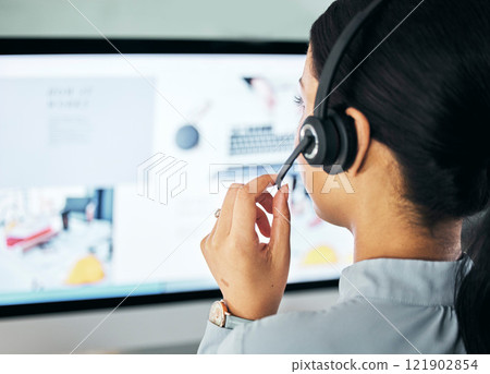 Call center agent giving online support with computer screen, working as advisor and doing telemarketing in an office at work from behind. Closeup of customer service representative talking with pc Call center agent giving online support with computer screen, working as advisor and doing telemarketing in an office at work from behind. Closeup of customer service representative talking with pc 121902854