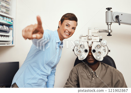 Happy optometrist doing eye test on a patient, examining vision and doing optical exercise at an optometry checkup. Young black man consulting with an opthalmologist, measuring and checking eyesight 121902867