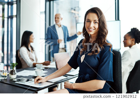 Corporate manager feeling positive about the leadership in a meeting conference. Confident female office worker or businesswoman sitting in a boardroom presentation with her colleagues. Corporate manager feeling positive about the leadership in a meeting conference. Confident female office worker or businesswoman sitting in a boardroom presentation with her colleagues. 121902912