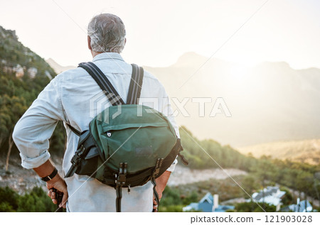 Rear view of exploring, active and adventure senior man standing with a backpack after a hike, enjoying the landscape and forest nature. Male hiker looking at nature environment sunrise view 121903028
