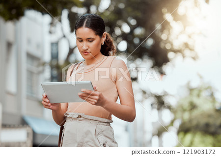 Reading, checking or browsing social media on tablet while out commuting through city and looking for directions or inspiration online. Young entrepreneur using business website tool for ideas 121903172