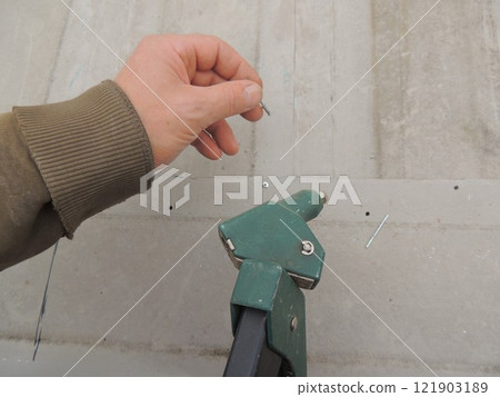 Hand with metal rivet and tool for fixing iron sheets, upper part of riveting device and aluminum bracket for fastening metal 121903189