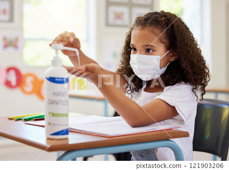 School kid using hand sanitizer for germ protection, hygiene and disinfection during covid protocol regulations in a classroom. Young student cleaning hands for safety of flu, corona and virus School kid using hand sanitizer for germ protection, hygiene and disinfection during covid protocol regulations in a classroom. Young student cleaning hands for safety of flu, corona and virus 121903206