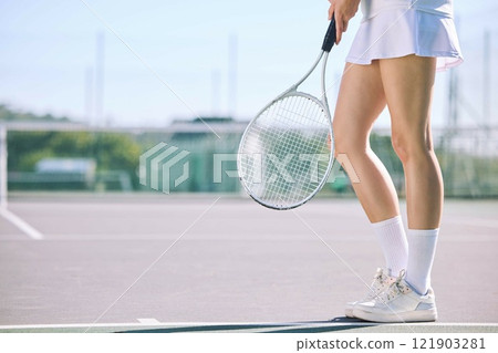 Legs of a female tennis player practicing or training for a match outdoors on the court on a sunny day. Active, fit and athletic female athlete or sportswoman playing a sport for a club 121903281