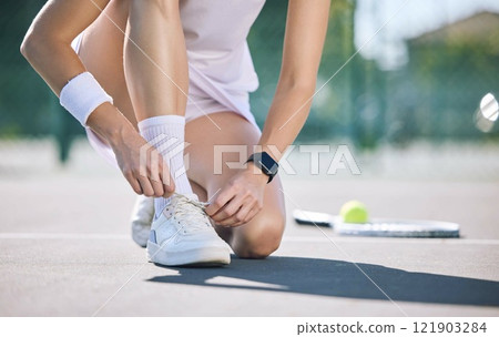 Female tennis player foot and hands tying shoelaces before game match on outdoor sports court. Active, sporty woman preparing for training for fun, summer exercise and healthy, wellness lifestyle. 121903284