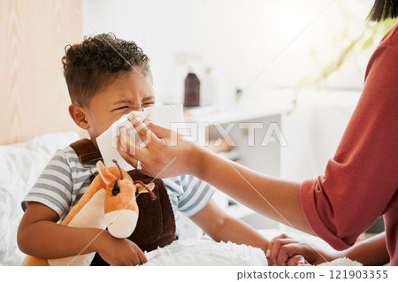 Flu, sick or cold child with parent sneezing, blowing and wiping runny nose while ill with covid virus, sinus and allergy symptoms in bed at home. Mother caring for stuffy and congested little son 121903355